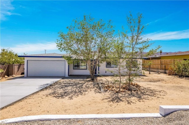 ranch-style home featuring fence, an attached garage, driveway, and stucco siding
