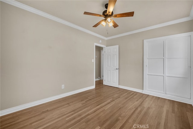 unfurnished bedroom with baseboards, light wood finished floors, crown molding, and ceiling fan