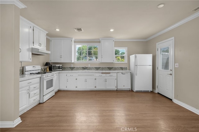 kitchen featuring a sink, white cabinets, tile counters, under cabinet range hood, and white appliances