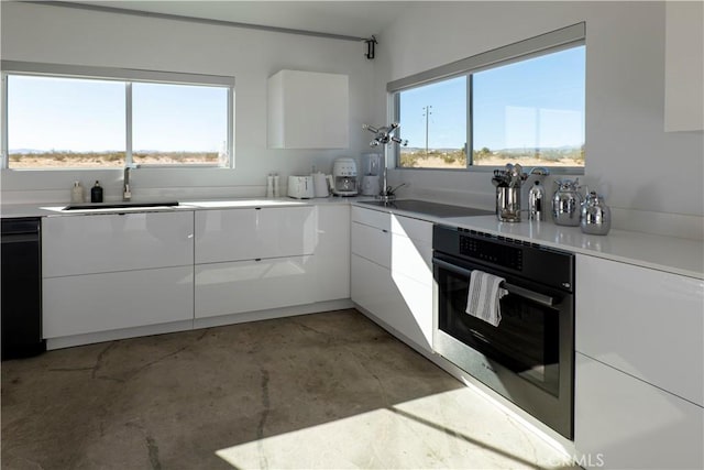 60810 Cole Ln, Landers, CA 92285 - kitchen featuring a sink, white cabinetry, wall oven, modern cabinets, and unfinished concrete floors