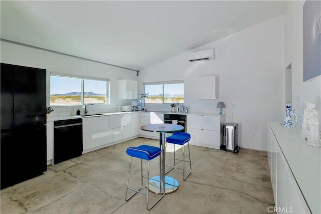 60810 Cole Ln, Landers, CA 92285 - kitchen featuring black appliances, a wall mounted AC, modern cabinets, lofted ceiling, and concrete flooring