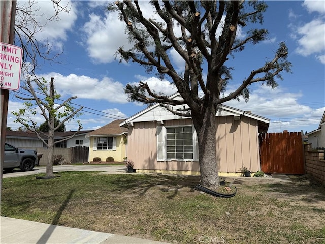 view of front of house with fence, driveway, and a front lawn