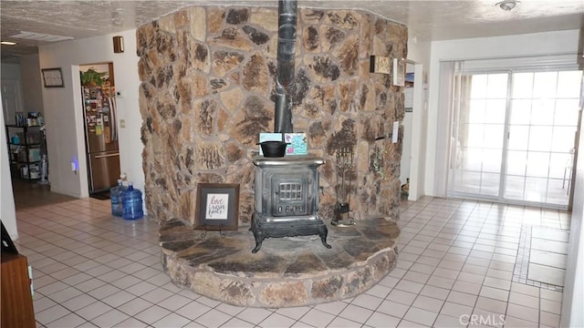 details with a wood stove, a textured ceiling, and freestanding refrigerator