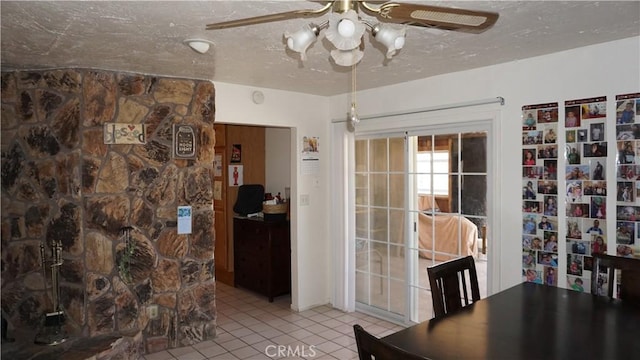 office area with a textured ceiling, ceiling fan, and light tile patterned flooring