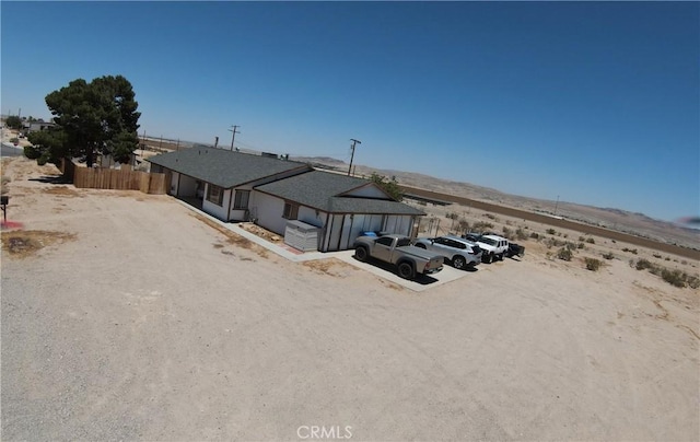 rear view of house with fence and a mountain view