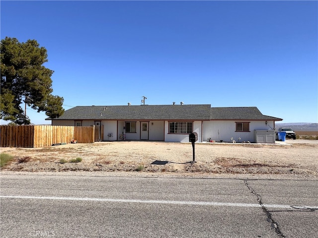 ranch-style home featuring fence