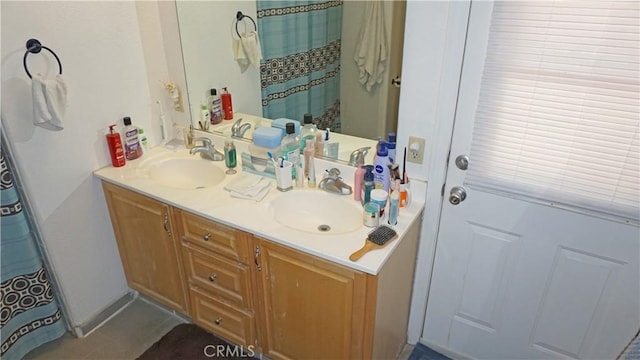 bathroom featuring double vanity, curtained shower, and a sink