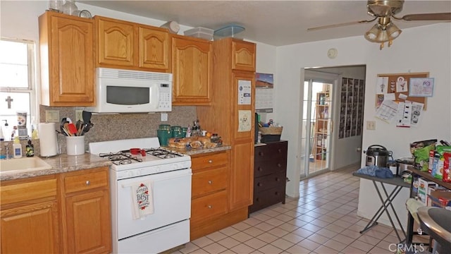 kitchen featuring plenty of natural light, a ceiling fan, white appliances, and tasteful backsplash