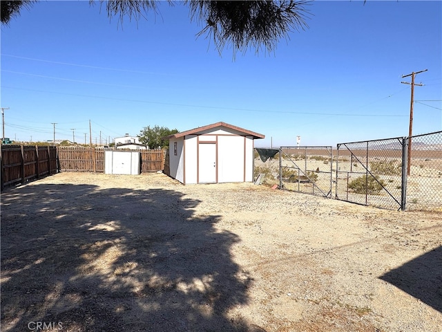view of yard with an outdoor structure, a fenced backyard, and a storage unit