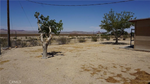 view of yard with fence, a mountain view, and a rural view
