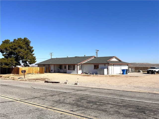 ranch-style home with an attached garage, fence, and driveway