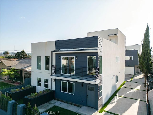 2937 W Blvd, Los Angeles, CA 90016 - view of front of property with a garage, a garden, stucco siding, and a balcony