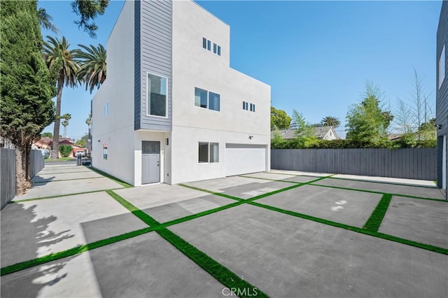 2937 W Blvd, Los Angeles, CA 90016 - back of property featuring stucco siding, an attached garage, fence, and a patio