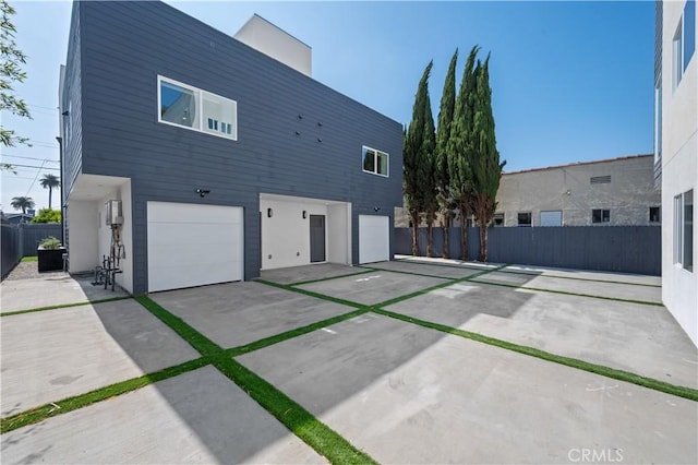 2937 W Blvd, Los Angeles, CA 90016 - rear view of house with fence, an attached garage, and driveway