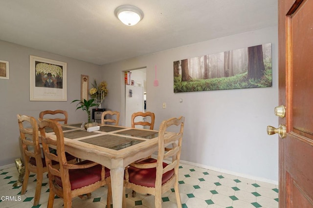 dining space with baseboards and light floors