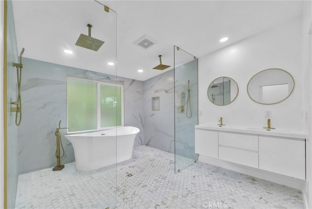 full bathroom with double vanity, a sink, a freestanding bath, and a marble finish shower