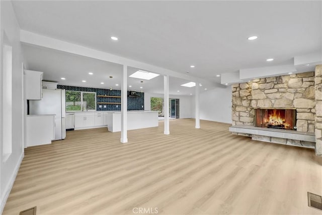 43 Rockinghorse Rd, Rancho Palos Verdes, CA 90275 - unfurnished living room featuring light wood finished floors, healthy amount of natural light, a stone fireplace, recessed lighting, and baseboards