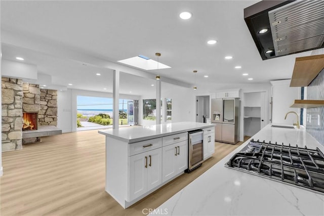 43 Rockinghorse Rd, Rancho Palos Verdes, CA 90275 - kitchen with stainless steel appliances, wine cooler, exhaust hood, a sink, and white cabinetry