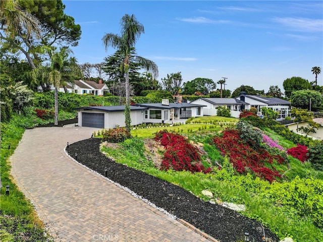 view of front of home with a residential view and decorative driveway