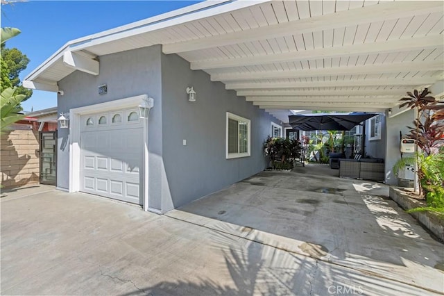 view of home's exterior with a garage, driveway, and stucco siding