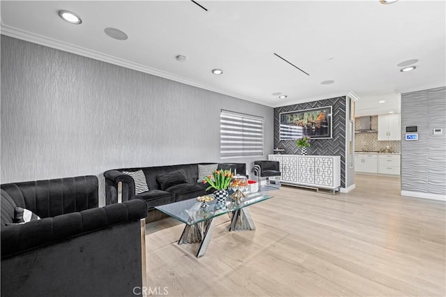 living room featuring recessed lighting, ornamental molding, and light wood-style floors