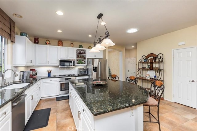 28345 Hearthside Dr, Menifee, CA 92584 - kitchen featuring a sink, appliances with stainless steel finishes, white cabinets, arched walkways, and a kitchen island