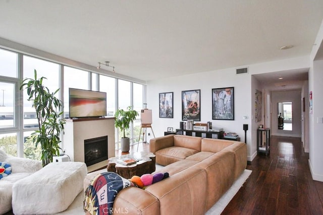 living area with visible vents, dark wood finished floors, baseboards, and a fireplace