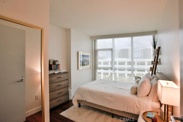 bedroom featuring dark wood-style flooring and baseboards