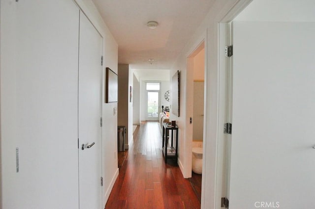 hall featuring baseboards and dark wood-style floors