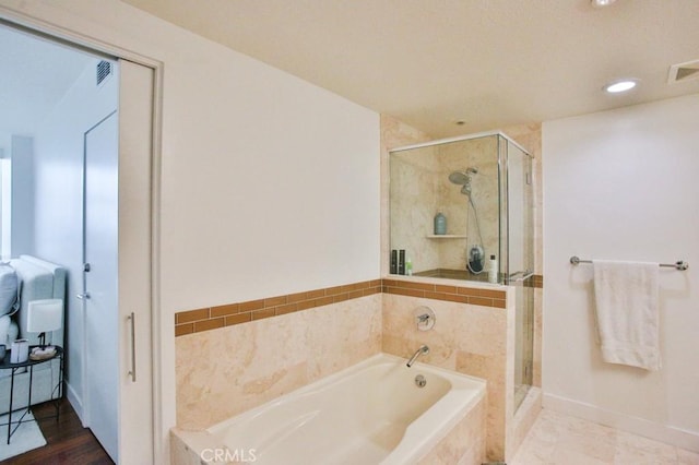 bathroom featuring baseboards, visible vents, a shower stall, and a garden tub