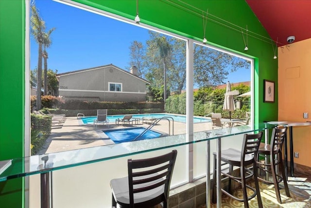 community pool with fence and outdoor dry bar