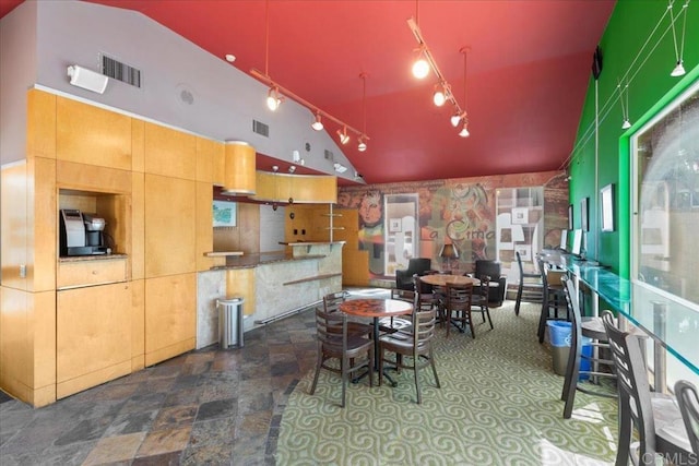 dining room with vaulted ceiling, track lighting, and visible vents