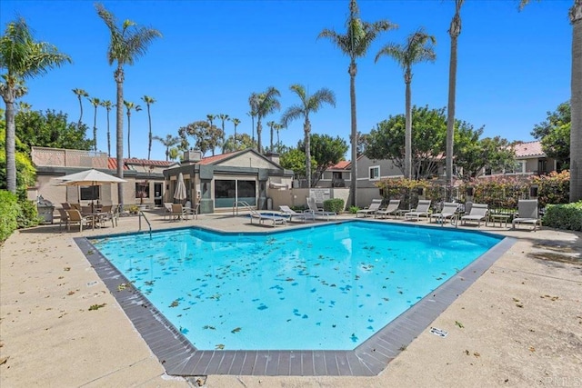 community pool featuring fence and a patio area