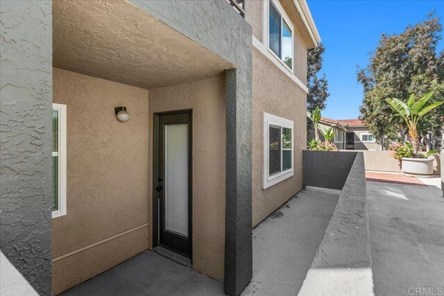 entrance to property with a patio area and stucco siding