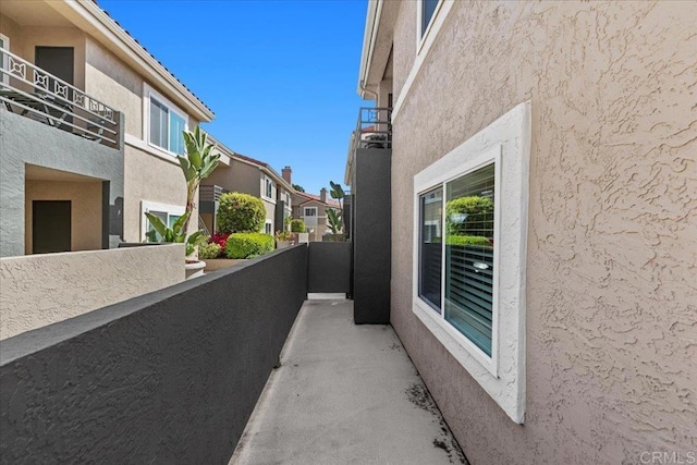 view of home's exterior featuring stucco siding, a balcony, and a residential view