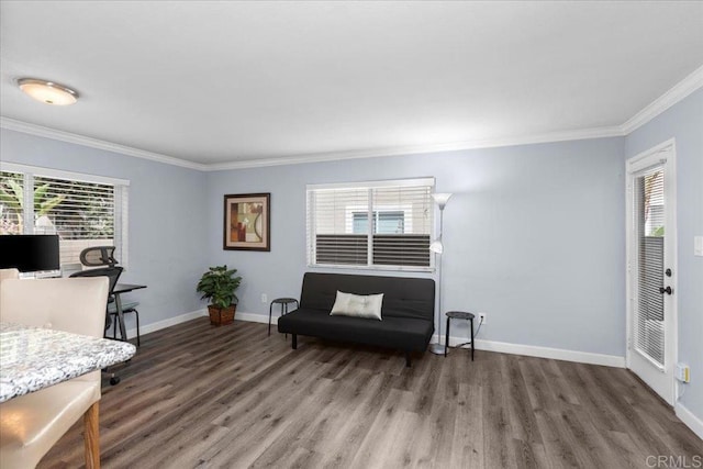 sitting room featuring baseboards, ornamental molding, and wood finished floors