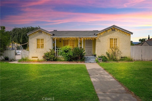view of front of home with a porch, a front lawn, and stucco siding