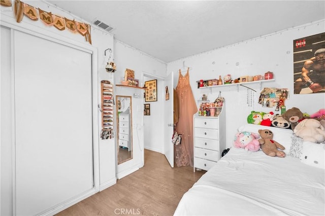 bedroom with visible vents and light wood-style flooring