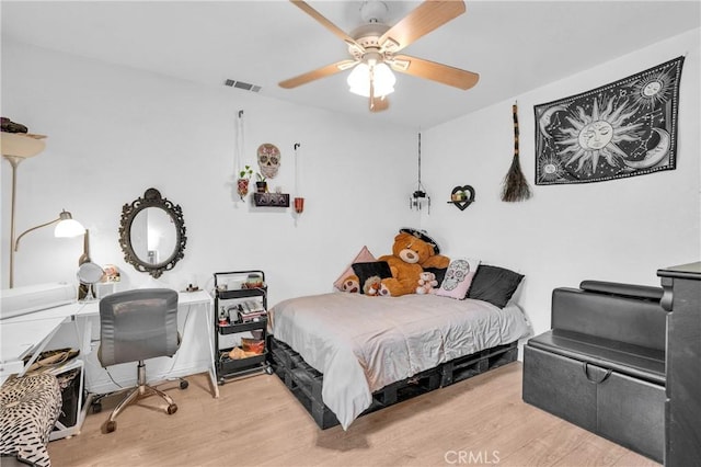 bedroom featuring ceiling fan, wood finished floors, and visible vents