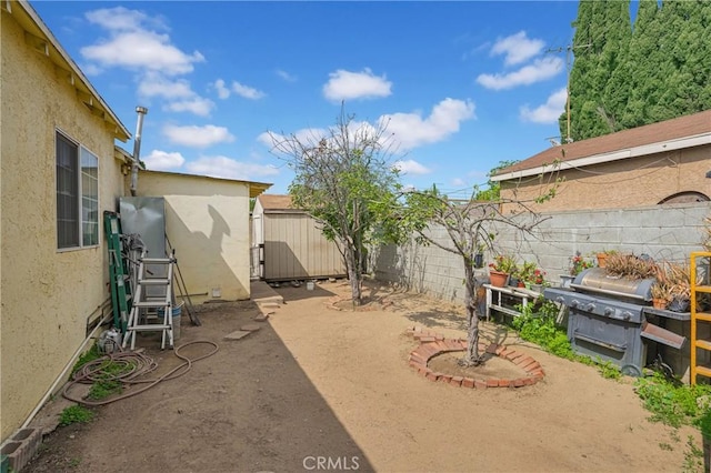view of yard with a fenced backyard, an outdoor structure, and a shed