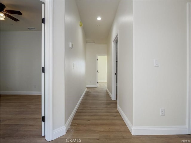 hallway with recessed lighting, baseboards, visible vents, and wood finished floors