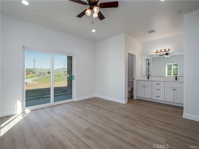 unfurnished bedroom featuring baseboards, access to outside, light wood-type flooring, and connected bathroom