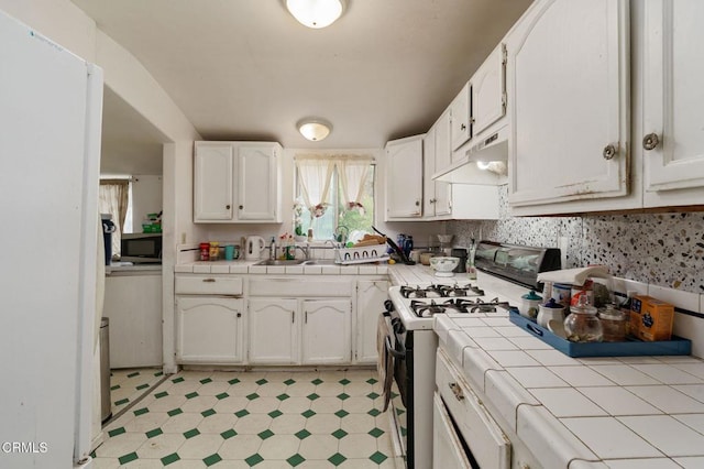 1151 Grant Line St Unit A & B, Santa Paula, CA 93060 - kitchen featuring light floors, gas range oven, tile countertops, under cabinet range hood, and white cabinets