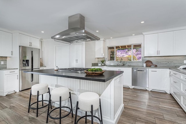 kitchen featuring island exhaust hood, appliances with stainless steel finishes, and white cabinets