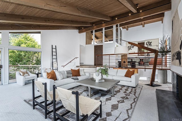 carpeted living area featuring stairs, beamed ceiling, and wooden ceiling