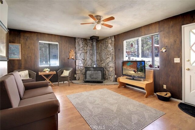 133 Holmes Ln, Sugarloaf, CA 92386 - living area with a wood stove, ceiling fan, wood finished floors, and wooden walls
