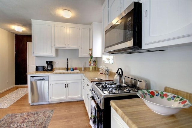 133 Holmes Ln, Sugarloaf, CA 92386 - kitchen featuring white cabinetry, appliances with stainless steel finishes, a sink, and light wood-type flooring