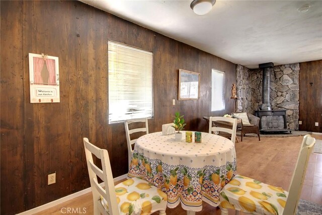 133 Holmes Ln, Sugarloaf, CA 92386 - dining area with wood walls, wood finished floors, and a wood stove