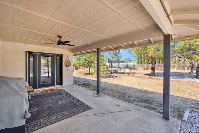 view of patio / terrace with a ceiling fan, a trampoline, and fence