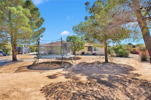 view of yard featuring a playground and a trampoline